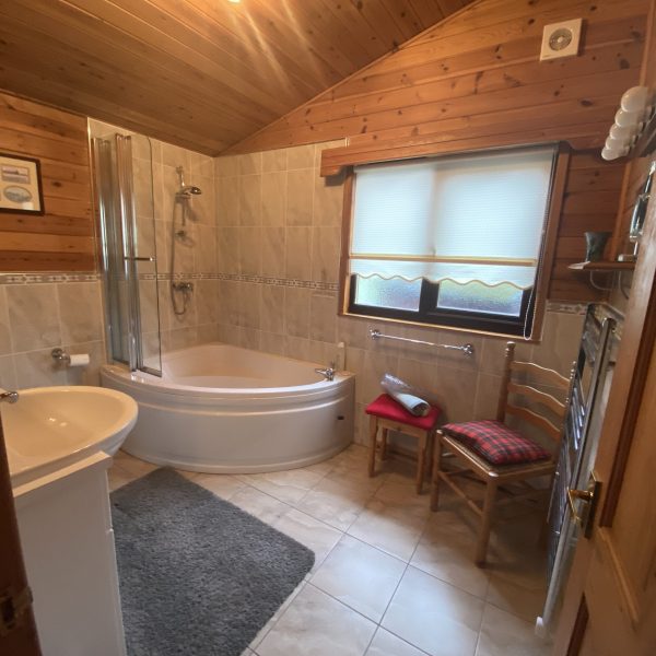 Master bathroom with soaking tub, vanity mirrors, and warm towel rail. Rowardennan, Loch Lomond Holiday Lodge